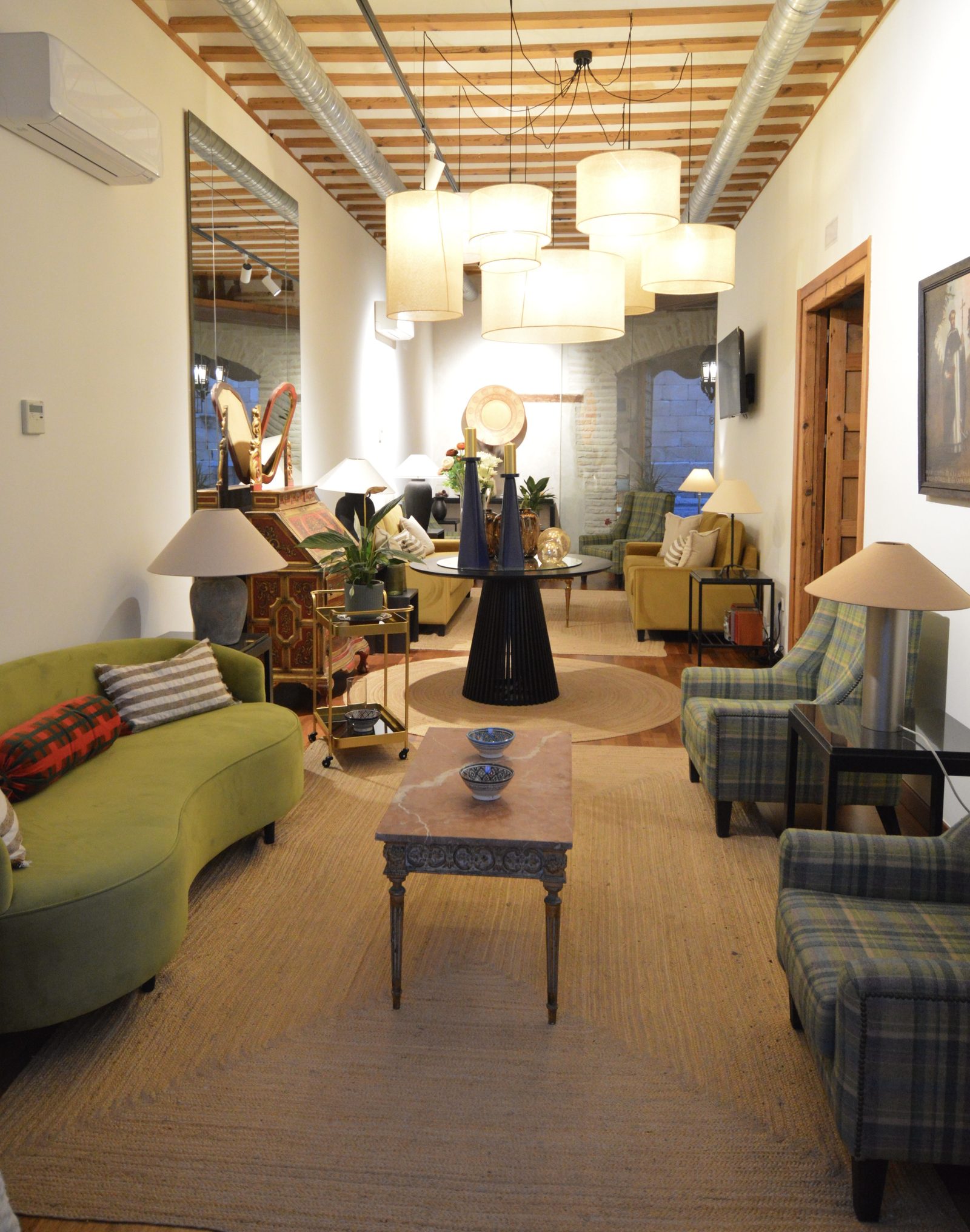 Salón del Casón del Conde, con butacas y sofás bajo vigas de madera