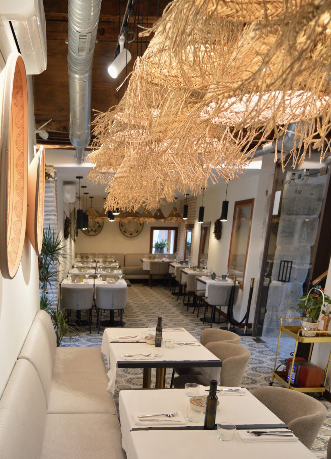 Comedor del Restaurante La Condesa con las mesas puestas bajo lámparas de fibra natural