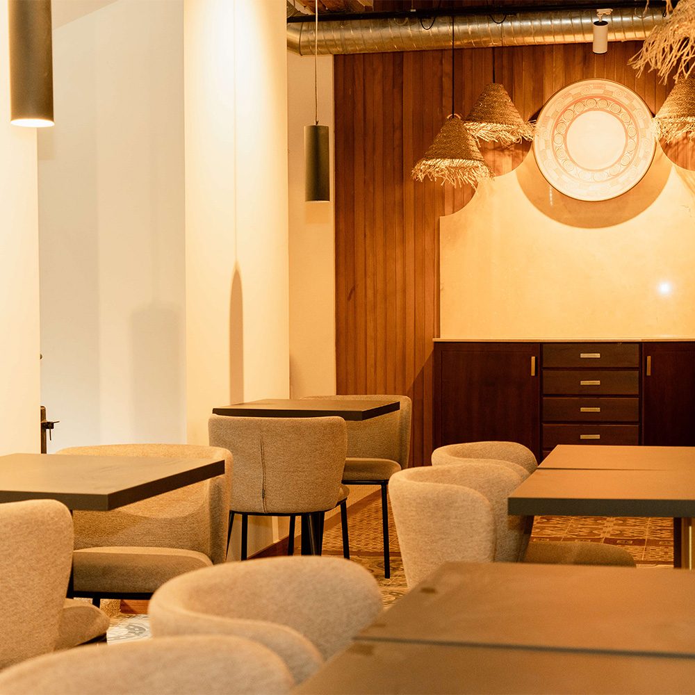 Comedor del Casón del Conde con mesas de madera, butacas tapizadas y suelo hidráulico