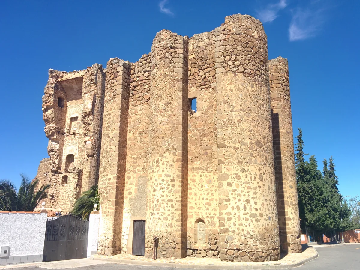 Torreón del castillo de Polán, con sus cubos de mampostería, en la calle del pueblo